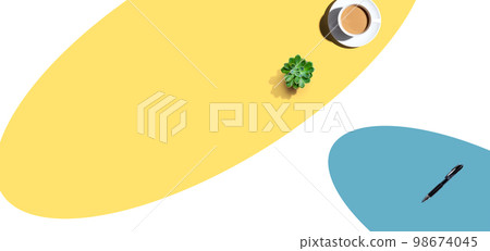 A cup of coffee and and a pen on an open writing desk 98674045