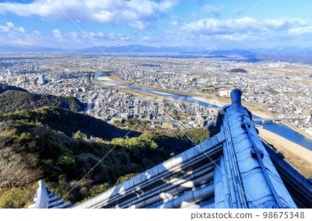 Gifu Prefecture, Gifu Castle's ridge-end tiles and the view of Gifu City (West direction, towards Mt. Ibuki) 98675348