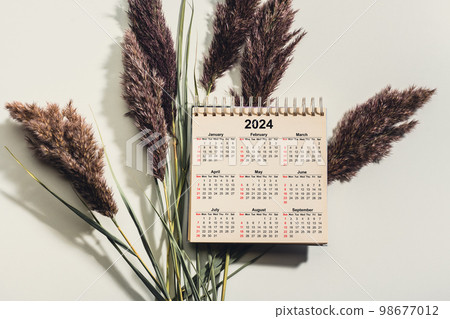 2024 Happy New Year. 2024 desk calendar notepad on white table and gray background. New Year plans for 2024. dry grass 2024 Happy New Year. 2024 desk calendar notepad on white table and gray background. New Year plans for 2024. dry grass 98677012