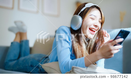 Happy young asian woman relaxing at home Happy young asian woman relaxing at home 98677142
