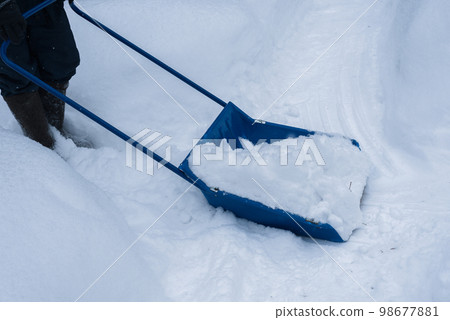 Man cleaning snow with shovel in winter day. Man cleaning snow with shovel in winter day. 98677881