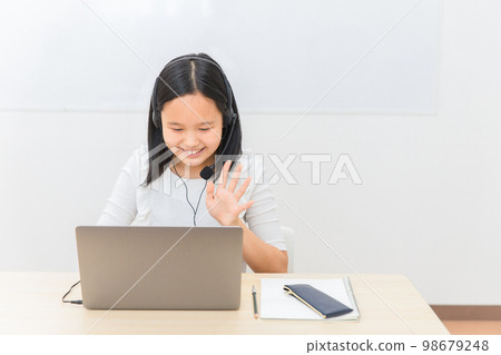 Elementary school and junior high school children (girls) who make video calls and video calls on a personal computer Elementary school and junior high school children (girls) who make video calls and video calls on a personal computer 98679248