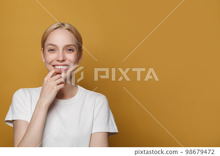 Cute attractive smiling woman on bright yellow background 98679472
