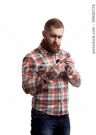 Portrait of handsome bearded redhead man in checked shirt who holds pipe isolated white background  98680728