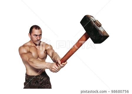 Strong man with naked torso who strikes with a sledgehammer while isolated on white background 98680756