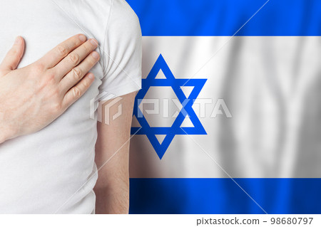 Izraeli person with hand on heart on Izrael flag. Patriotism, country, national, pride concept Izraeli person with hand on heart on Izrael flag. Patriotism, country, national, pride concept 98680797