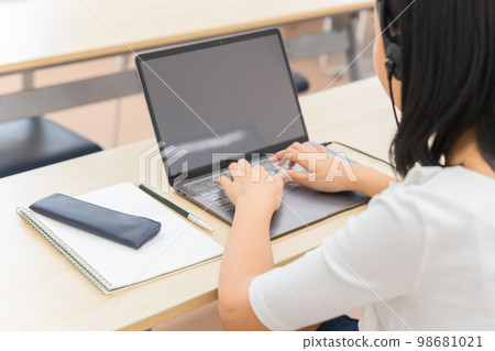 Back view of children (elementary school students, junior high school students, high school students) who are learning online and ICT education at school / computer classroom 98681021