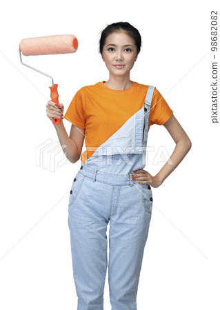 Asian young housewife holding roller paint brush Asian young housewife holding roller paint brush 98682082