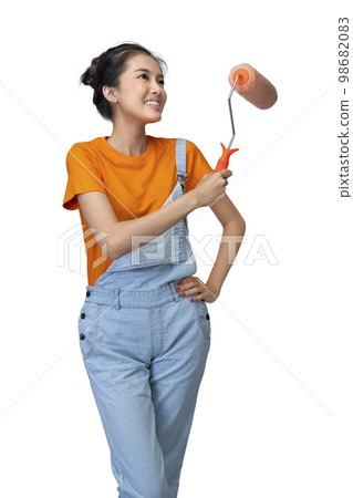 Asian young housewife holding roller paint brush Asian young housewife holding roller paint brush 98682083