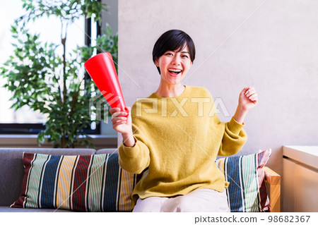 Young woman watching sports on TV [Enjoying time at home] 98682367