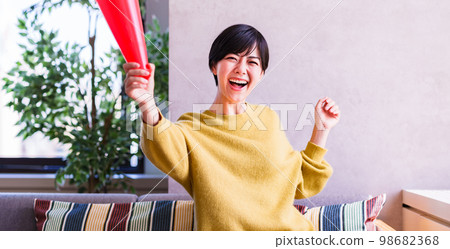 Young woman watching sports on TV [Enjoying time at home] 98682368