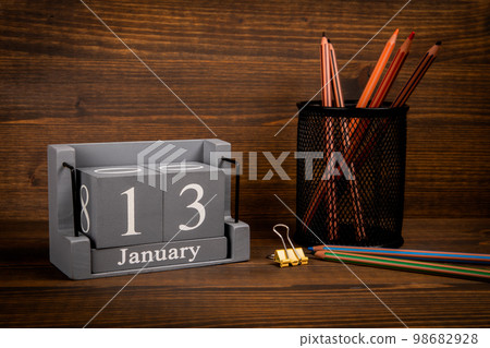 13 January inscription on wooden calendar. Wooden office desk 13 January inscription on wooden calendar. Wooden office desk 98682928