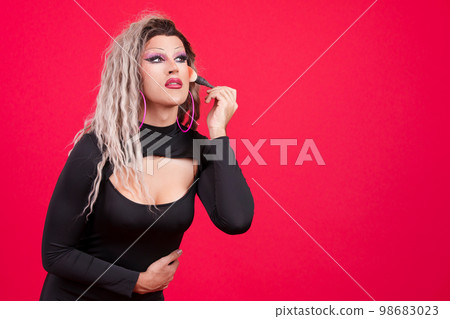 Transgender person dressed as drag queen making up 98683023