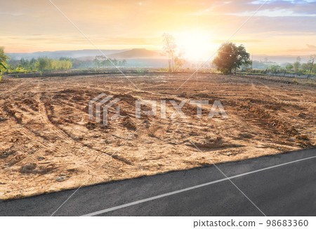 Empty dry cracked swamp reclamation soil, land plot for housing construction project with car tire print in rural area and beautiful blue sky with fresh air Land for sales landscape concept 98683360