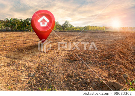 House symbol with location pin and Empty dry cracked swamp reclamation soil, land plot for housing construction project with and beautiful sunset sky with fresh air Land for sales landscape concept House symbol with location pin and Empty dry cracked swamp reclamation soil, land plot for housing construction project with and beautiful sunset sky with fresh air Land for sales landscape concept 98683362