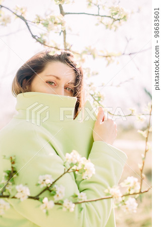 stylish woman green coat background spring flowering stylish woman green coat background spring flowering 98683601