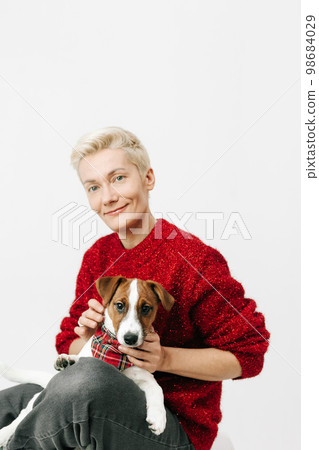 blonde woman happily playing pet jack russell 98684029