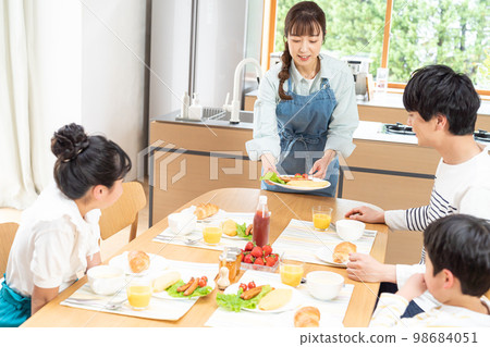 Family of four eating in the dining room Family of four eating in the dining room 98684051