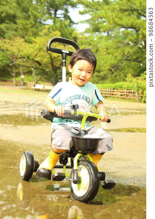 child riding a tricycle child riding a tricycle 98684363