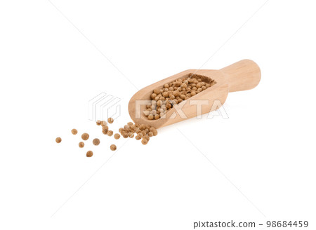 coriander seeds in  wooden scoop on white background. 98684459