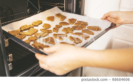 Close up of Christmas pastries,  gingerbread cookies, ready to bake traditional Xmas and New Year pastry on white paper. 98684606