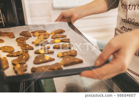 Close up of Christmas pastries,  gingerbread cookies, ready to bake traditional Xmas and New Year pastry on white paper. 98684607