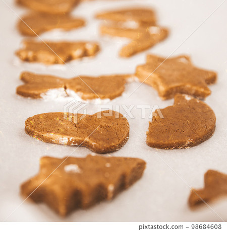 Close up of Christmas pastries,  gingerbread cookies, ready to eat traditional Xmas and New Year pastry on white paper. 98684608