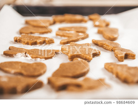 Close up of Christmas pastries,  gingerbread cookies, ready to eat traditional Xmas and New Year pastry on white paper. 98684609