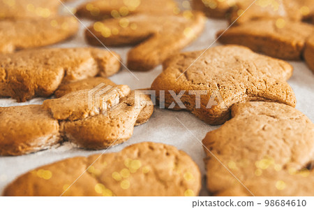 Close up of Christmas pastries,  gingerbread cookies, ready to eat traditional Xmas and New Year pastry on white paper. 98684610