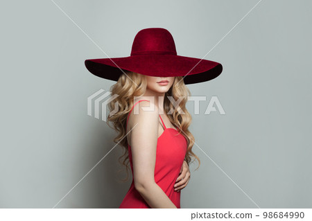 Pretty woman blonde fashion model in red wide broad brim hat on white background 98684990