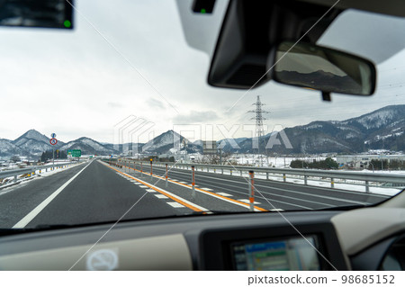Scenery of a snowy country, snow-plowed highways and snow-covered mountains Scenery of a snowy country, snow-plowed highways and snow-covered mountains 98685152