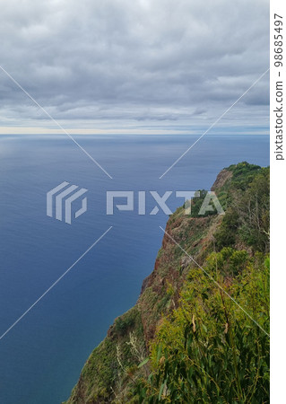 The green slope of a mountain on an island in the Atlantic Ocean. 98685497