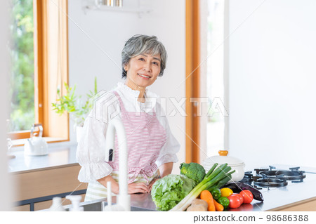 站立在廚房裡的微笑的資深婦女 98686388