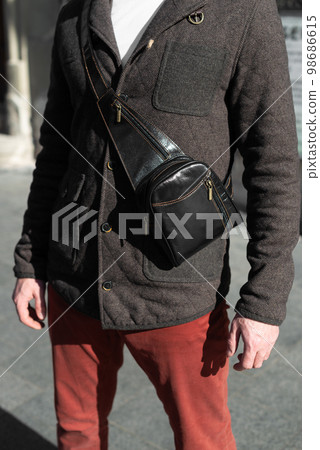 close-up photo of black banana leather bag on mans shoulder 98686615