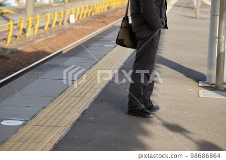 Commuter train in the morning and male passengers waiting for the train at the station Commuter train in the morning and male passengers waiting for the train at the station 98686864
