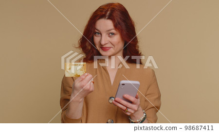 Young woman using credit bank card and smartphone while transferring money purchases online shopping 98687411