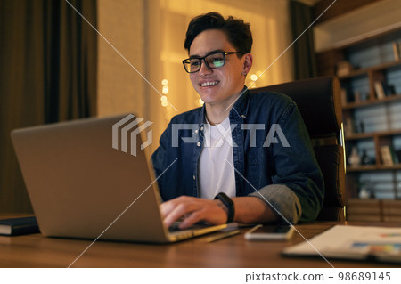 Handsome young happy IT specialist working on computer at office Handsome young happy IT specialist working on computer at office 98689145