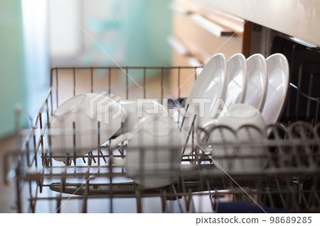 Closeup Shot Of Open Built-in Dishwasher Machine With Clean Dishes 98689285