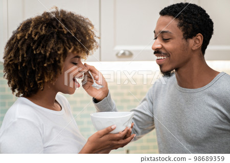 Closeup of african american man feeding his pretty girlfriend 98689359