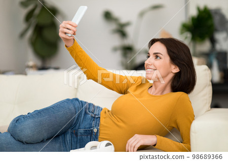Cute young woman blogger taking selfie at home Cute young woman blogger taking selfie at home 98689366
