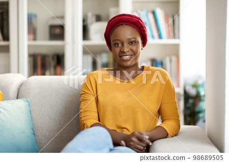 Young calm black woman relaxing on sofa in living room 98689505