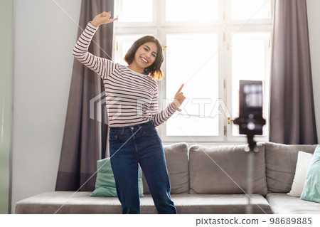 Happy Young Arab Woman Dancing At Camera While Recording Video At Home Happy Young Arab Woman Dancing At Camera While Recording Video At Home 98689885
