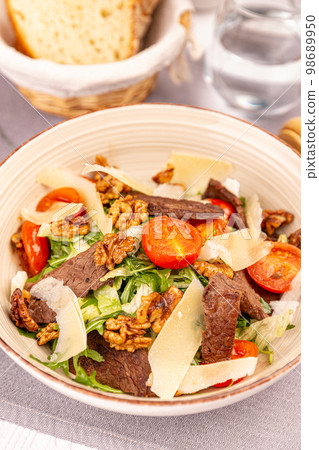 Sliced grilled beef steak with green leaves salad 98689950