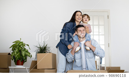 Family Housing. Happy parents with little son posing in new home after moving 98690118