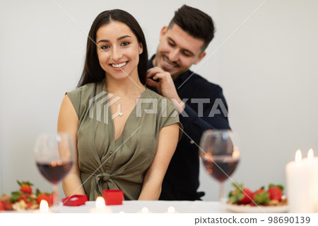 Happy young couple in love drinking wine, celebrating Valentines day 98690139