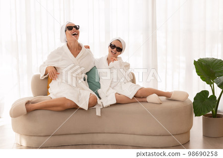 Mother And Little Daughter Wearing Bathrobes And Sunglasses Having Fun At Home 98690258
