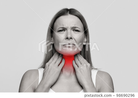 Woman suffering from sore throat, touching her neck Woman suffering from sore throat, touching her neck 98690296