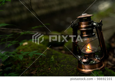 Antique lantern placed near the river 98692101