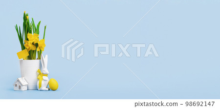 Yellow Easter eggs in a nest and daffodils in a white pot and Easter bunny with tiny house on blue background. Mockup tag. Happy Easter wide web banner Yellow Easter eggs in a nest and daffodils in a white pot and Easter bunny with tiny house on blue background. Mockup tag. Happy Easter wide web banner 98692147