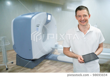 Doctor on the background of a CT scanner Doctor on the background of a CT scanner 98693834